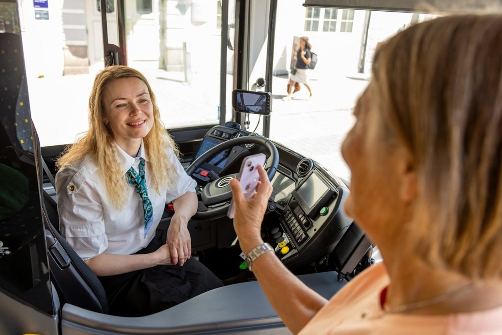 En passasjer viser fram FAIRTIQ-appen for bussjåføren – den nye billettløsningen skal gi automatisk rabatt til hyppige reisende.