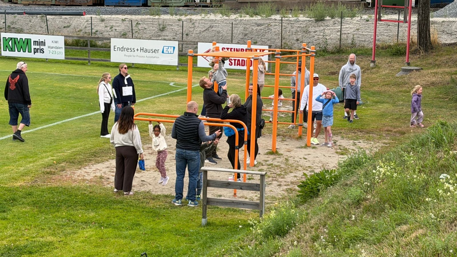 Barn og voksne samlet seg rundt klatrestativet under jubileumsfeiringen, der flere generasjoner fikk prøve aktivitetsapparatene sammen.
