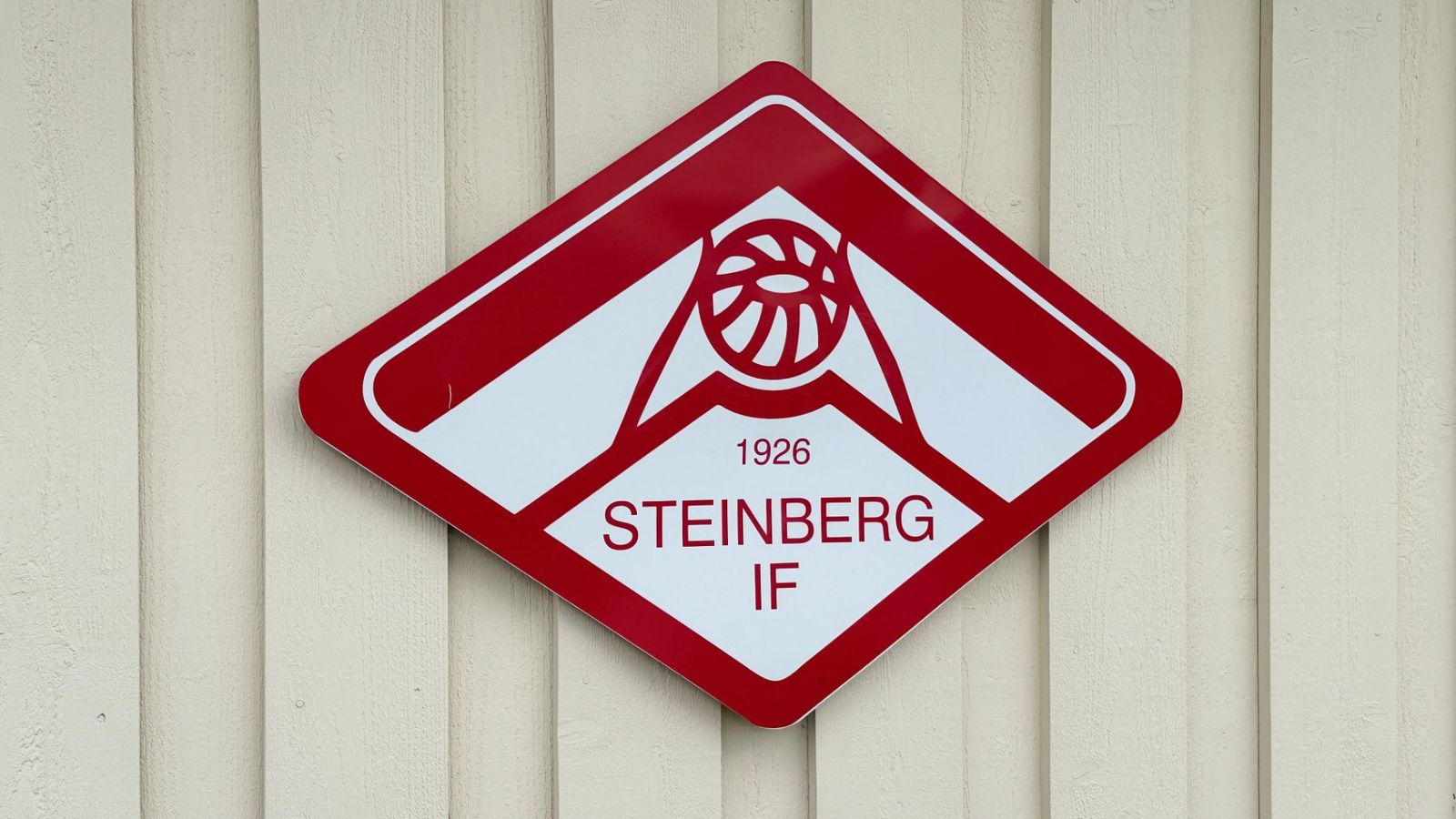Logoen til Steinberg IF, stiftet i 1926, henger på klubbhusveggen der laget nylig feiret 100-årsjubileum.