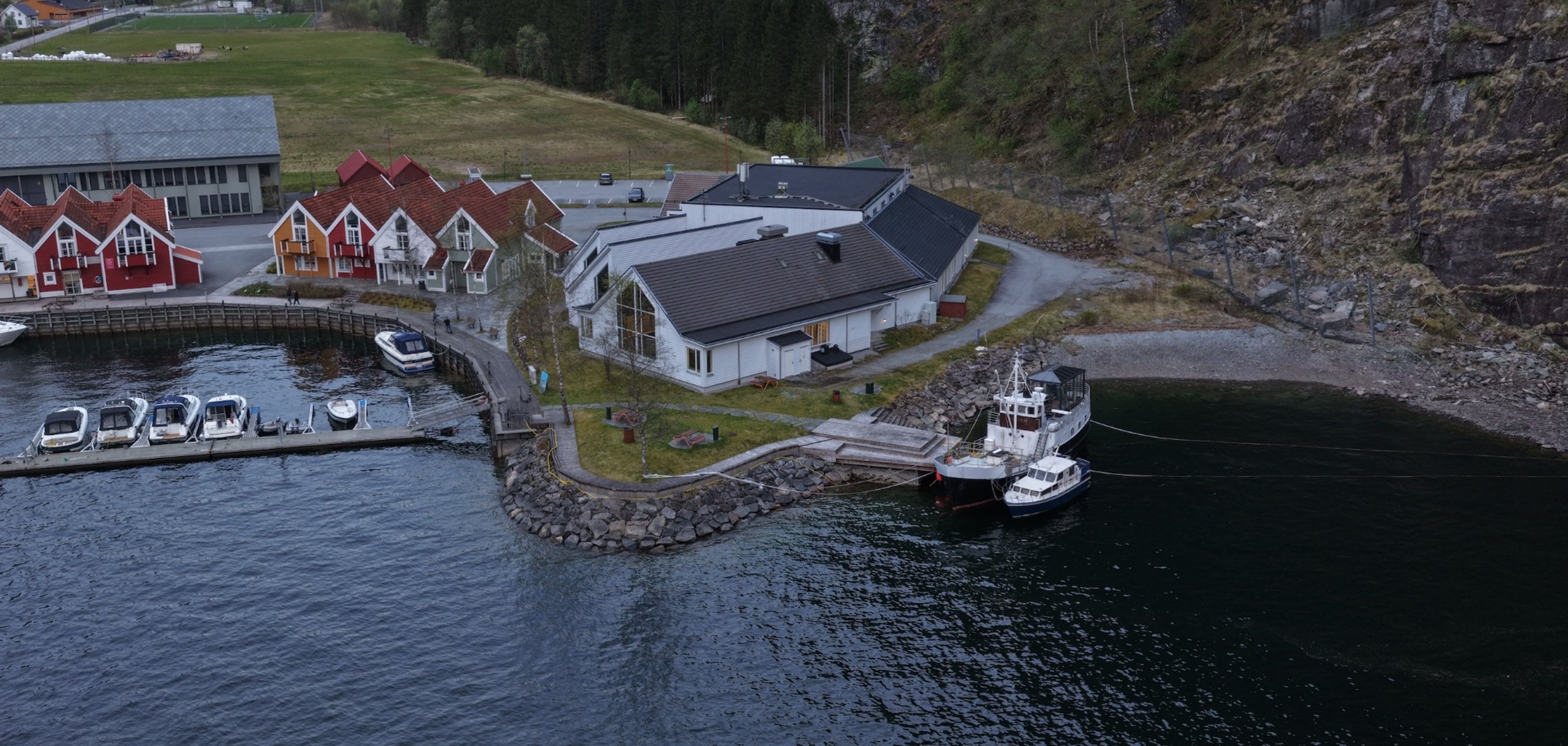 Bak Bryggjeslottet ligger det en båt som okkuperer bryggen for badende og andre gjester. 